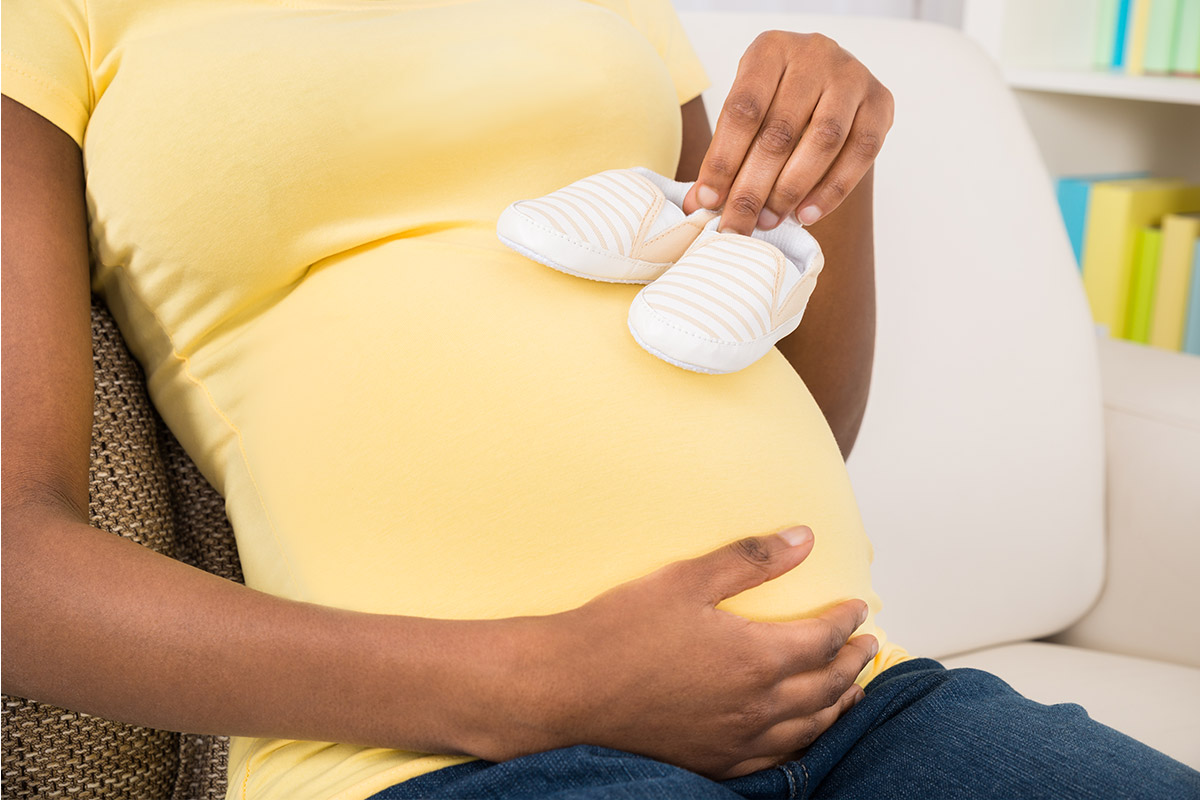 Pregnant mom with baby shoes